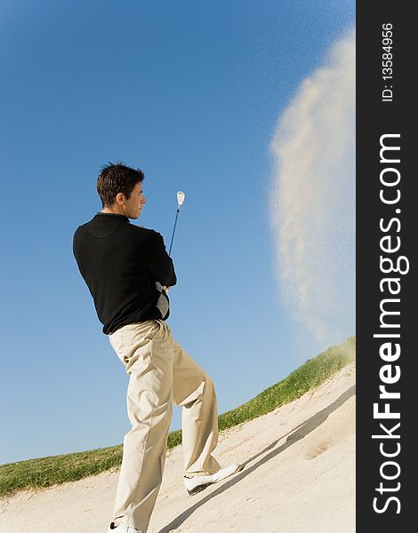 Golfer hitting ball from sand trap