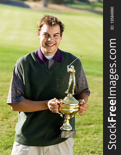 Young Golfer holding trophy, (portrait)