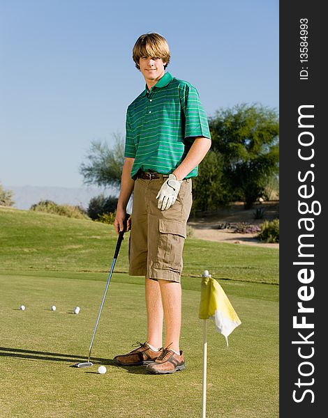 Young Golfer practising putting on course