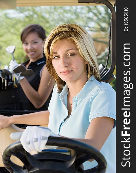 Two female golfers sitting in golf cart. Two female golfers sitting in golf cart