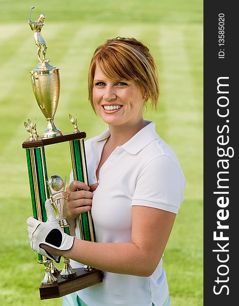 Female golfer holding trophy, (portrait)