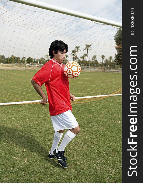 Soccer player juggling ball, portrait