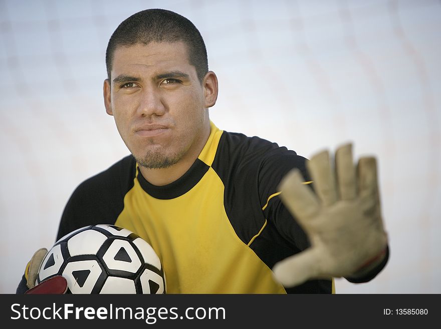 Goalkeeper holding ball close, portrait