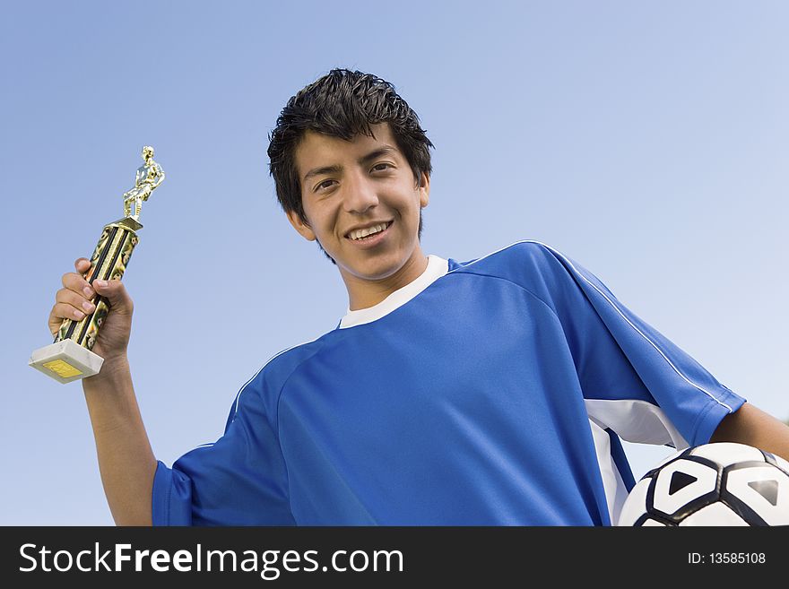 Soccer Player Holding Trophy And Ball