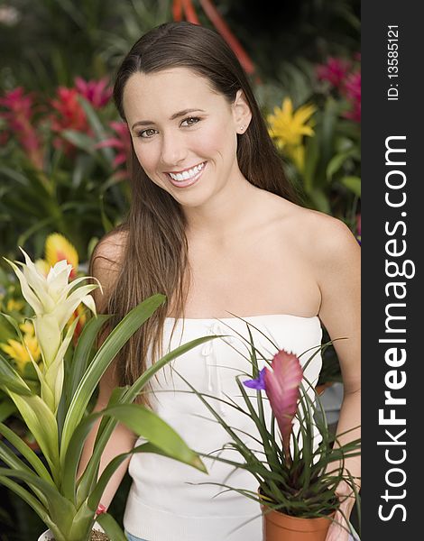 Young woman holding exotic potted plants, (portrait)