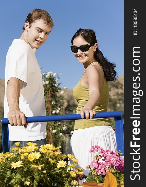 Young couple looking at potted flowers in garden centre