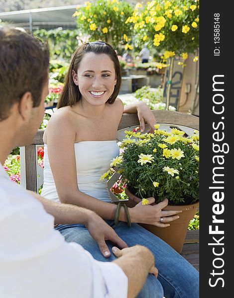 Young couple sitting on bench in garden