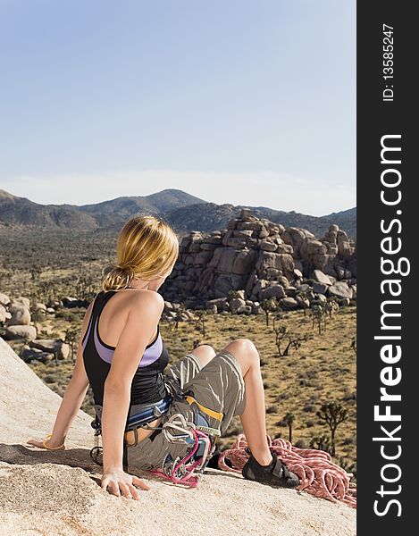 Female Climber on Rock Looking at Desert