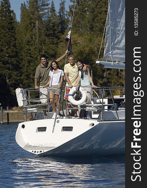 Two young couples standing on stern of sailboat. Two young couples standing on stern of sailboat