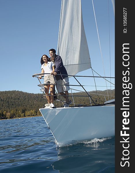 Young couple standing on bow of sailboat. Young couple standing on bow of sailboat