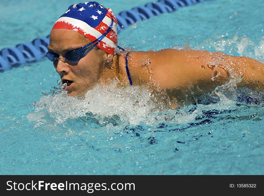 Woman swimming butterfly stroke, (close-up)