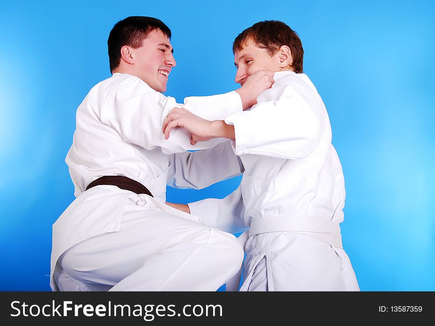 Two karatekas on a dark blue background. Two karatekas on a dark blue background.