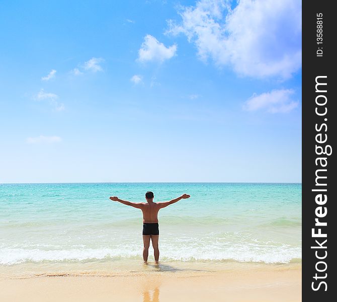 Relaxed young man with his hands stretched, standing at the beach. Relaxed young man with his hands stretched, standing at the beach