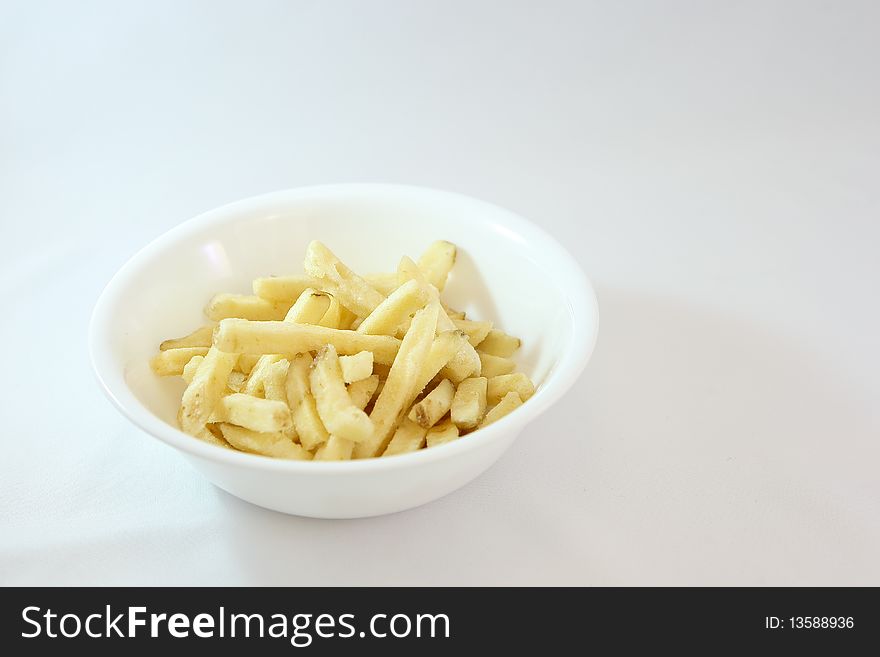 Delicious french fry sticks in a bowl on white background. Delicious french fry sticks in a bowl on white background.
