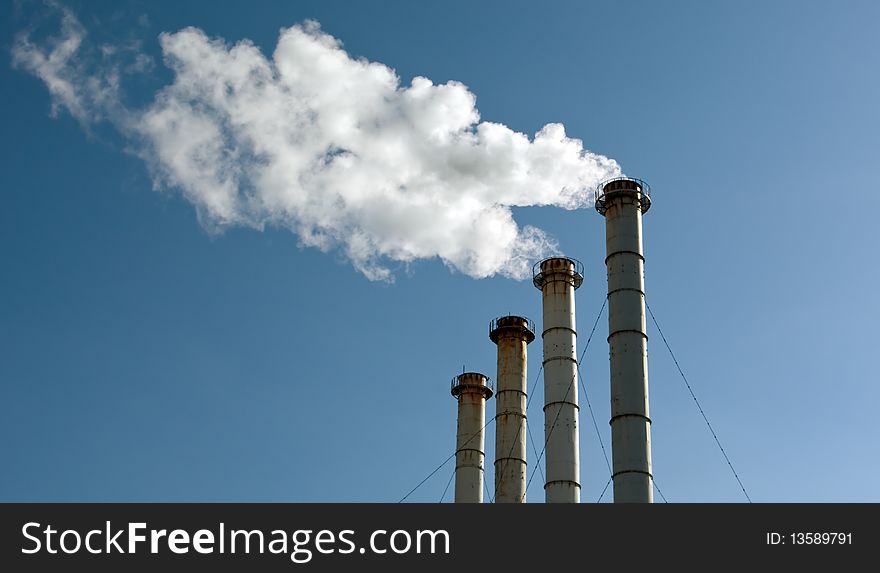 Industrial exhaust pipes on dark-blue sky background