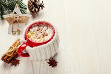 Winter Coffee Drink, Cocoa With Whipped Cream And Marshmallows In A Red Ceramic Cup. It Stands On A White Wooden Table, Next To A Royalty Free Stock Photography Winter Coffee Drink, Cocoa With Whipped Cream And Marshmallows In A Red Ceramic Cup. It Stands On A White Wooden Table, Next To A Royalty Free Stock Photography