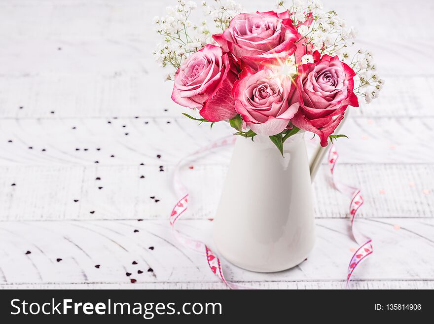 Pink roses in a white pitcher. Valentines day greeting card. Copy space