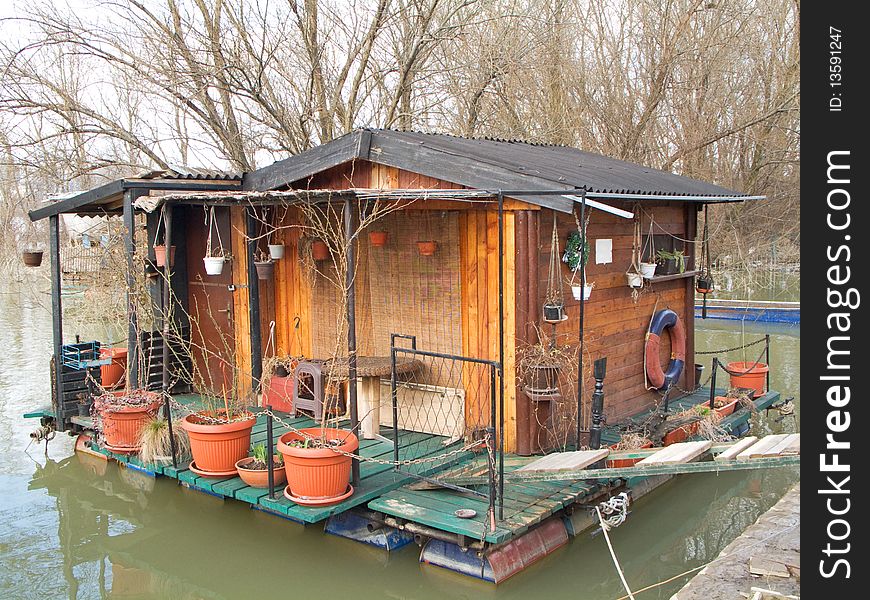 Wooden raft house cottage on river in winter time. Wooden raft house cottage on river in winter time