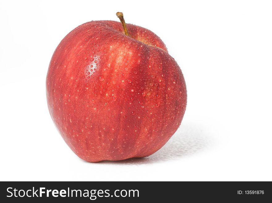 Fresh red apple with drops of water on a white background