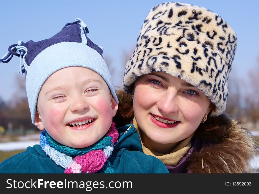 Mother and son laughing in the street, look in the lens of