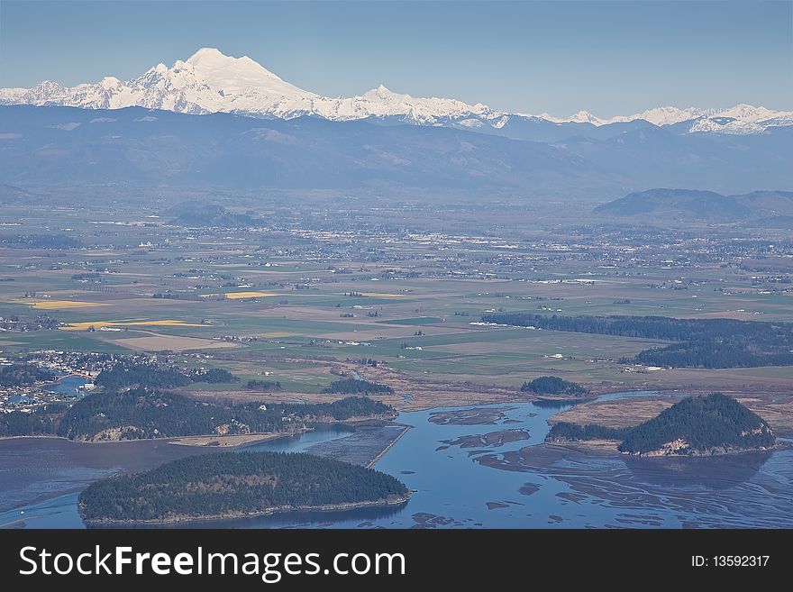 Aerial view of Skagit Valley Washington State with daffodil fields blooming in foreground and Mount Baker in background. Aerial view of Skagit Valley Washington State with daffodil fields blooming in foreground and Mount Baker in background