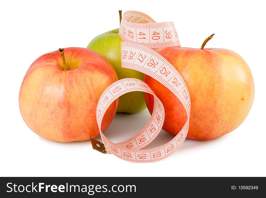 Pink measuring tape and three apples on a white background