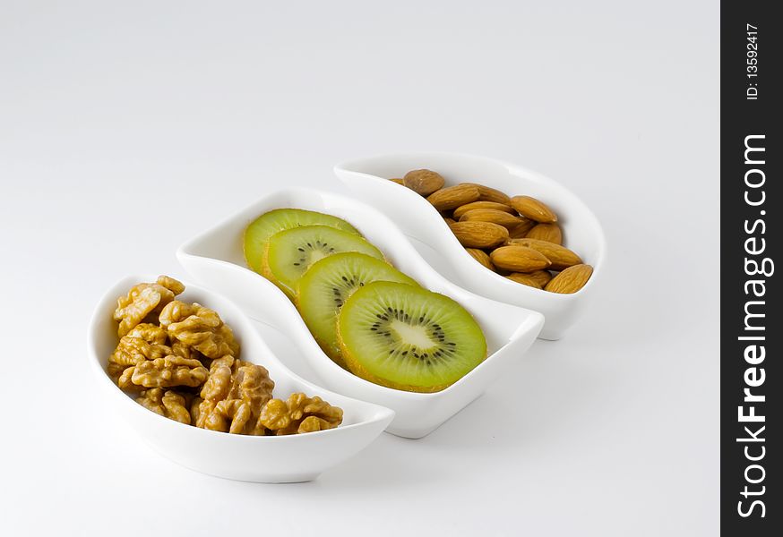 Kiwi fruit and nuts on white background