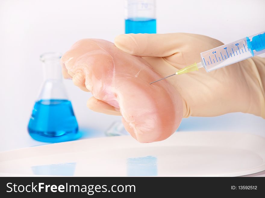 Researcher injecting GMO chicken meat. Genetically modified organism or GEO here transgenic plant is an plant whose genetic material has been altered using genetic engineering techniques known as recombinant DNA technology.