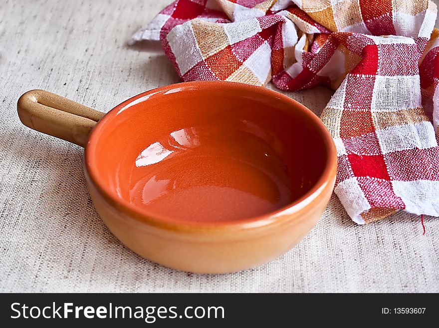 Ceramic bowl with kitchen towel on fabric background