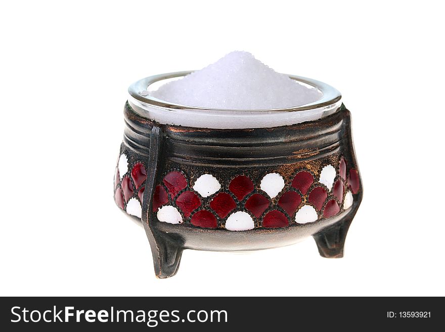 Ancient saltcellar with salt on a white background.