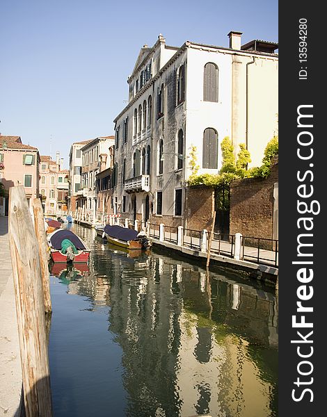 Boats at venetian canal among old and multicolored houses in (Grand canal, Venice, Italy). Boats at venetian canal among old and multicolored houses in (Grand canal, Venice, Italy)