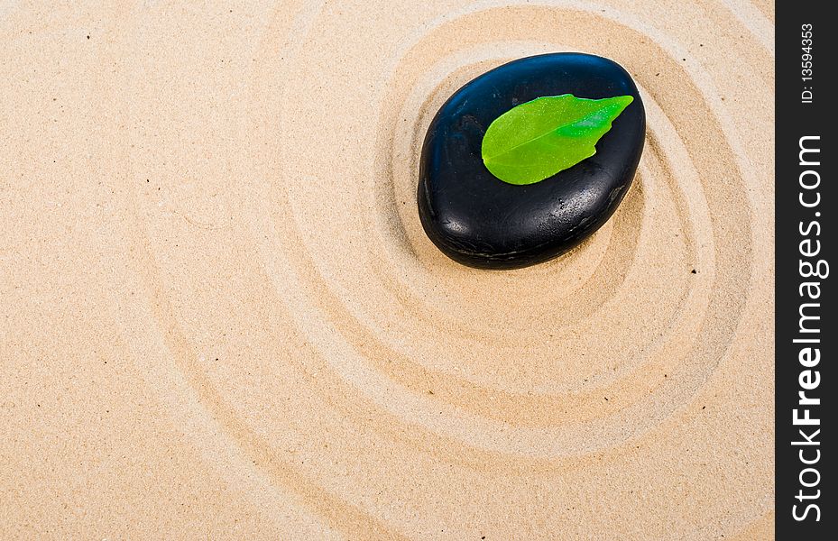 Zen stone, leaf on sand