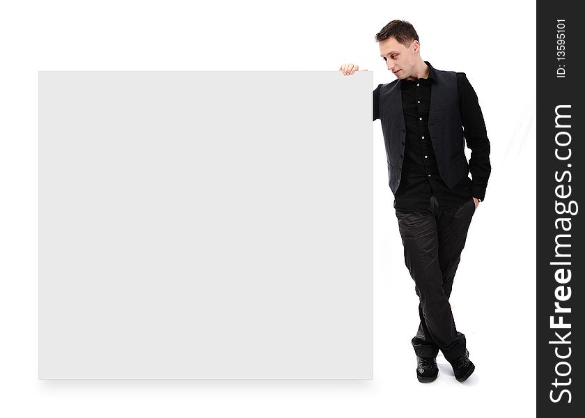 Young attractive man standing and holding white banner for your text or picture