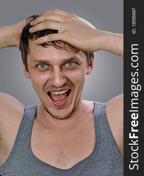 Portrait of shouting young man isolated on grey