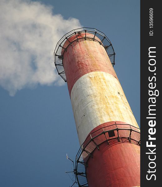 Old tall chimney painted white with red