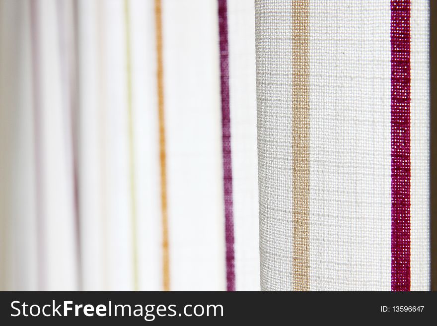 White curtain with yellow and purple stripe in a room