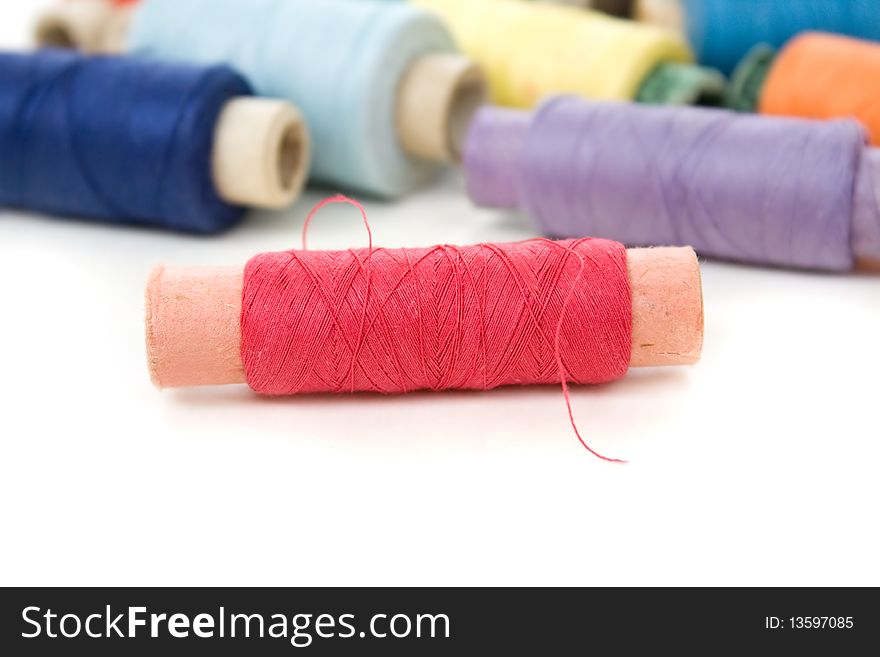 Multicolor thread reels on white background