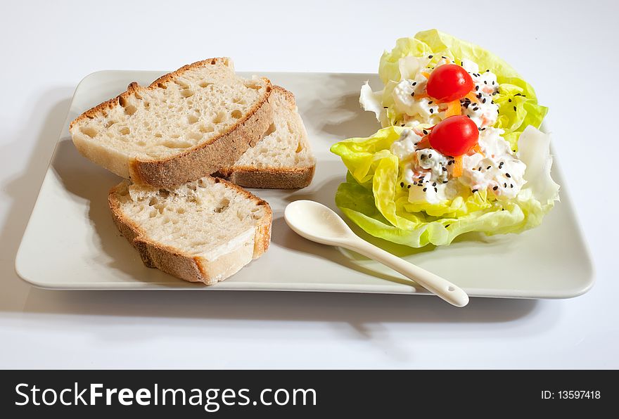 Russian salad plate with bread, lettuce and tomatoes on a saucer. Russian salad plate with bread, lettuce and tomatoes on a saucer