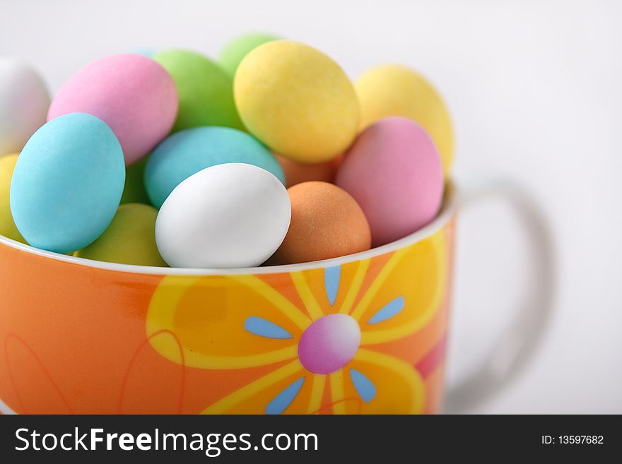 Cup full of colored easter eggs on a white background. Cup full of colored easter eggs on a white background