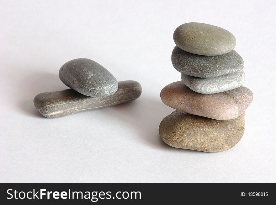 Tower of some stones over white and two stones in background