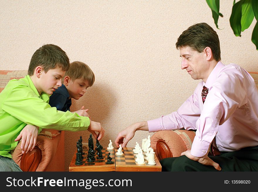 A father and his sons playing chess