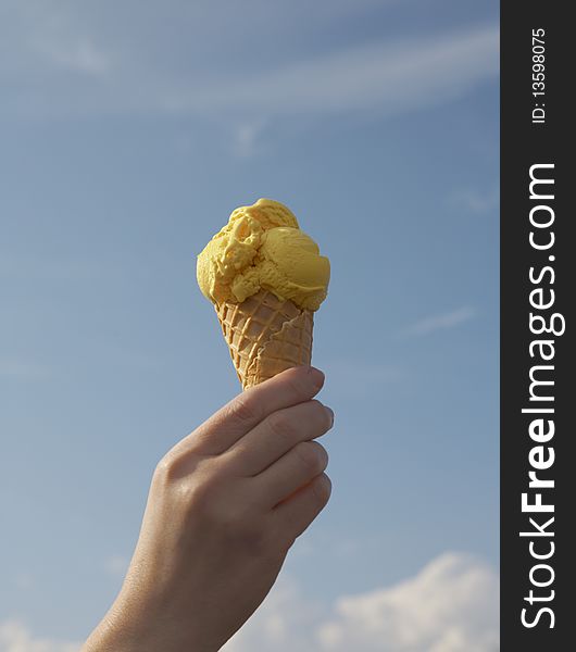 Ice cream in hand against the blue sky