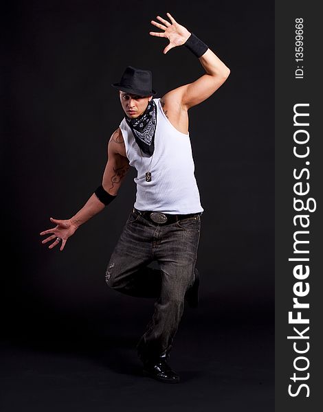 Young stylish asian dancer in front of black background moving to hip jop music. Young stylish asian dancer in front of black background moving to hip jop music.