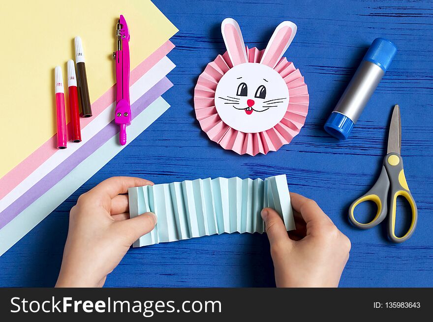 Child makes bunnies out of paper for Easter decoration. Creative idea for children`s party. DIY concept. Step by step photo instruction. Step 11. Fold paper accordion for little bunny. Child makes bunnies out of paper for Easter decoration. Creative idea for children`s party. DIY concept. Step by step photo instruction. Step 11. Fold paper accordion for little bunny