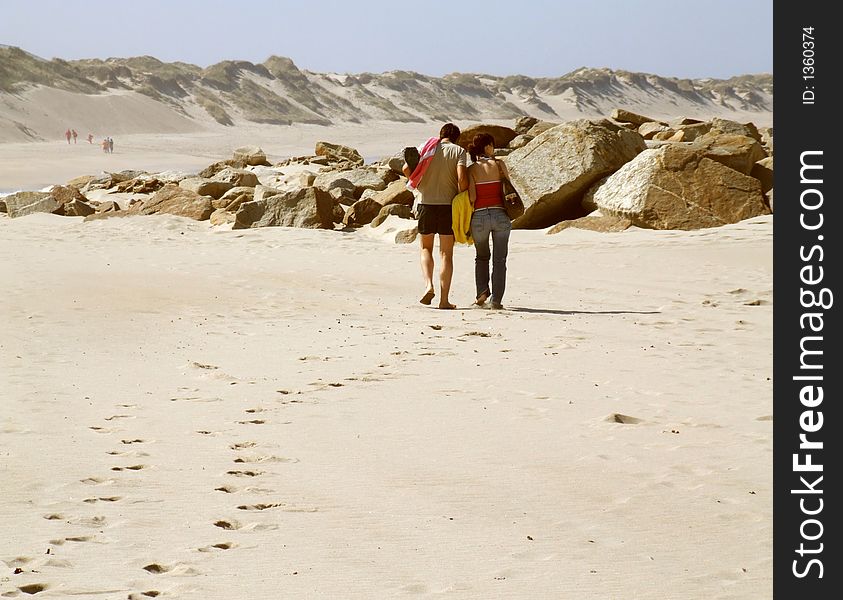 Couple Walking Along A Beach