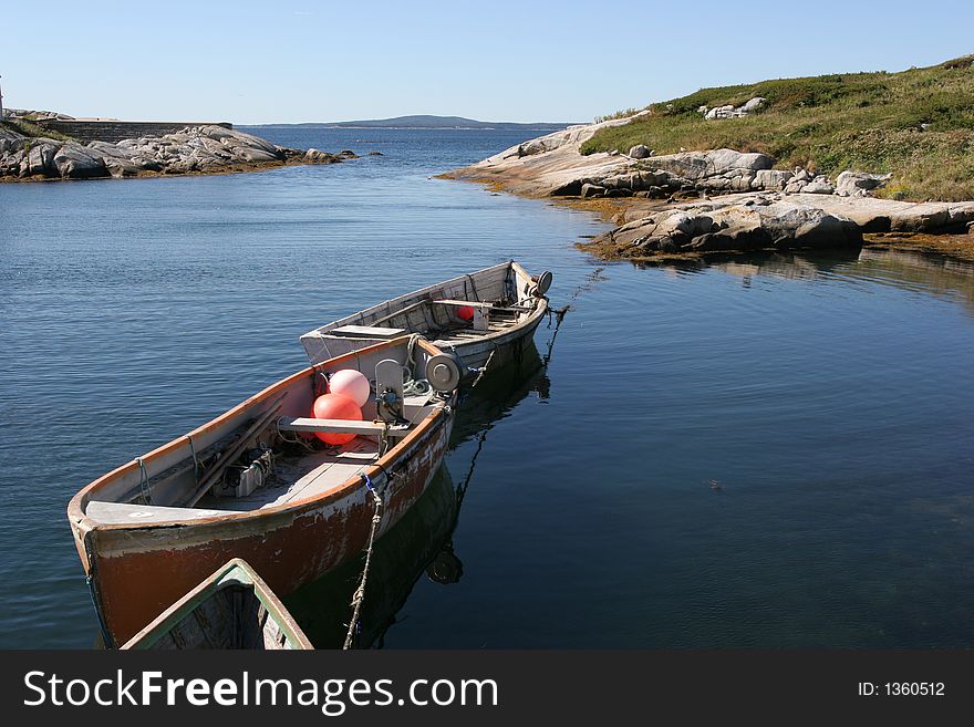 Three small boats in the water in PeggyÂ´s Cove. Three small boats in the water in PeggyÂ´s Cove