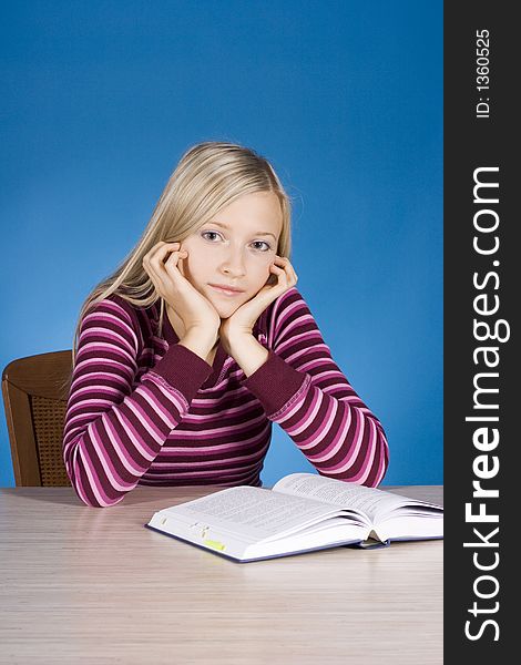 Young blonde woman with open book (blue background)