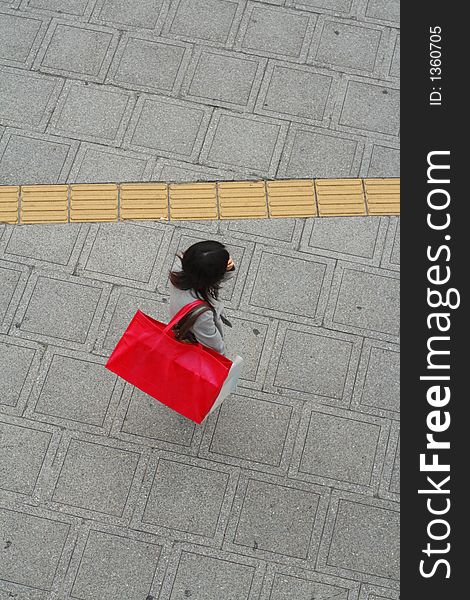 Woman with a big pink shopping bag in a city street-upper view. Woman with a big pink shopping bag in a city street-upper view