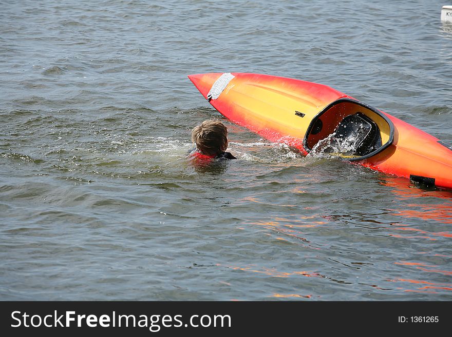 A lake in denmark with a boy falling out of a kayak. A lake in denmark with a boy falling out of a kayak