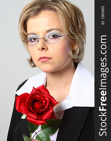 Blond woman with glasses and red rose looking at the camera
